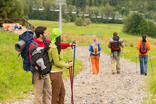 Hiking friends pointing and walking on trekking path
