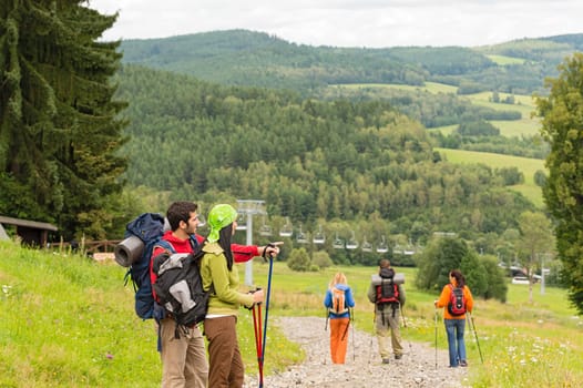 Young hikers with sticks enjoying scenic view on the mountain