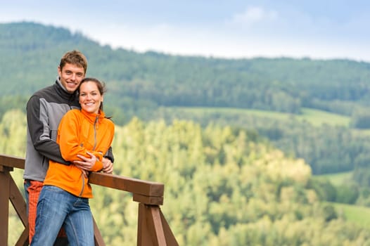 Cuddling couple on a summer weekend at the top of the mountain