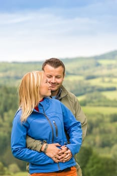 Lovely young couple cuddling with scenic landscape