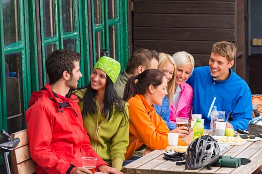 Carefree young people talking sitting with beers outdoors