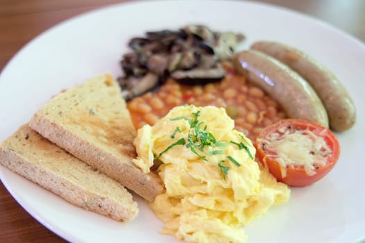 Scrambled Eggs Sausages with Bread Toast Baked Beans Sauteed Mushrooms and Tomato with Melted Cheese Breakfast