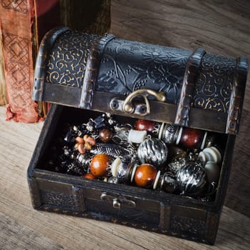 casket with jewelry and old book on a wooden surface