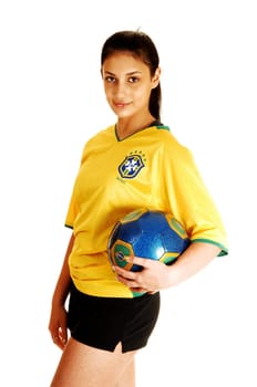 A young pretty soccer girl standing in her uniform, yellow top and black shorts, with a soccer ball in her hand for white background.