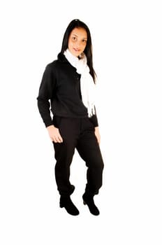A lovely young teenage girl in her school uniform, black top and long black pants, standing in the studio for white background.