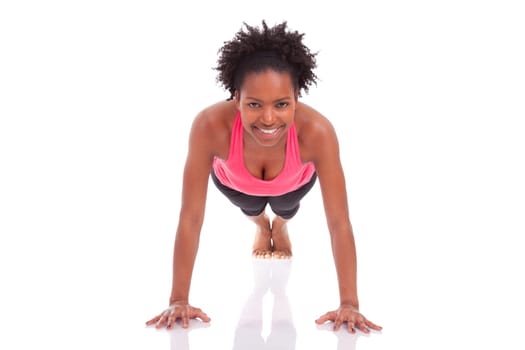 Young beautiful african fitness woman doing push up exercises on floor,isolated on white background