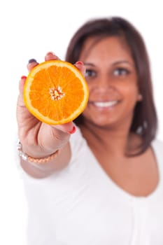 Young happy indian woman holding an orange slice, isolated on white background