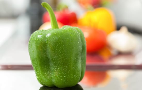 Fresh green pepper covered with water drops