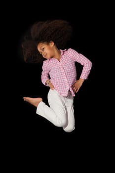 Portrait of cute Young African American girl jumping, over black background