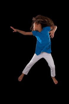 Portrait of cute Young African American girl jumping, over black background
