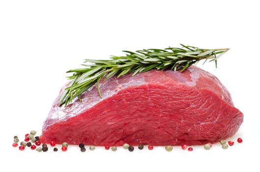 Raw roast beef with spices against a white background