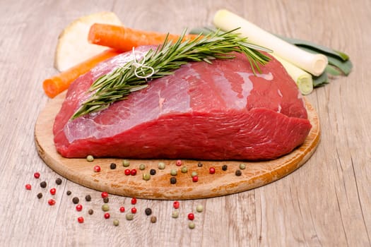 Raw beef roast with herbs and vegetables