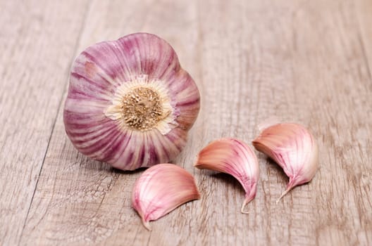 Garlic with garlic cloves on weathered wood