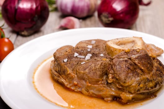 Braised veal shank slice with sauce and onions and garlic