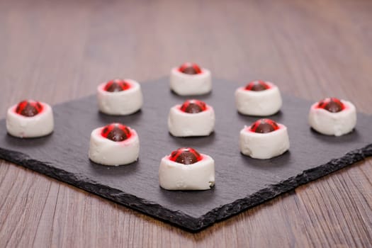 Goat's cream cheese with ladybugs made of icing on a slate plate