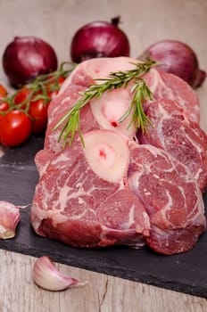 Raw veal leg slices for Italian osso buco with red onions