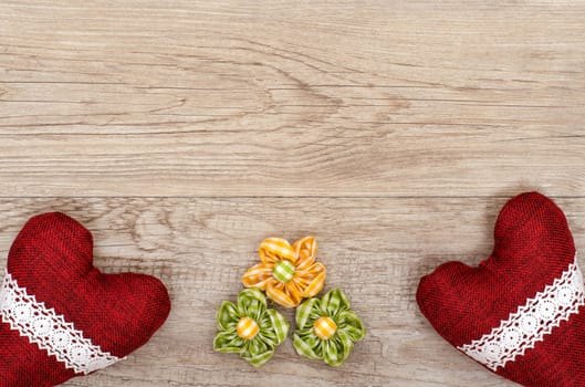 Advertising space on weathered wood with three fabric flowers and two fabric hearts