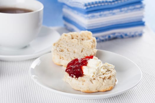 Scone with clotted cream and strawberry jam/preserves.