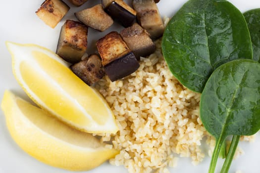 Fresh vegetable ingredients with spinach, eggplant/aubergine, lemon and bulgar
