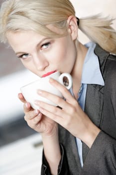 professional business woman drinking a mug of coffee at work.