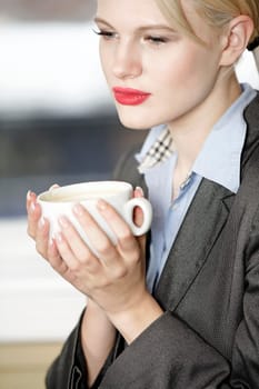 professional business woman drinking a mug of coffee at work.