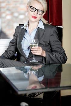 Attractive business woman in a wine bar waiting for a client or meeting.