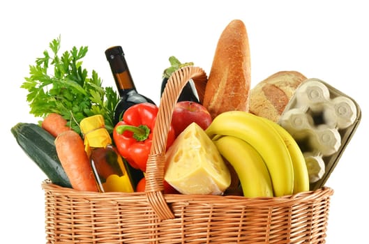 Wicker basket with variety of grocery products isolated on white