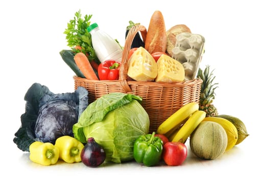 Wicker basket with variety of grocery products isolated on white