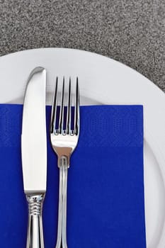 Plate with cutlery and blue napkin