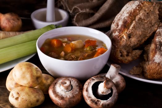 Home made soup and fresh vegetables with rustic bread