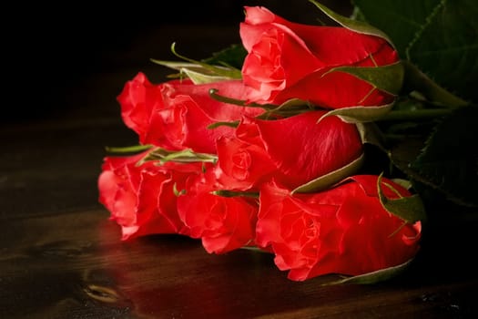 Red roses on a dark wood floor