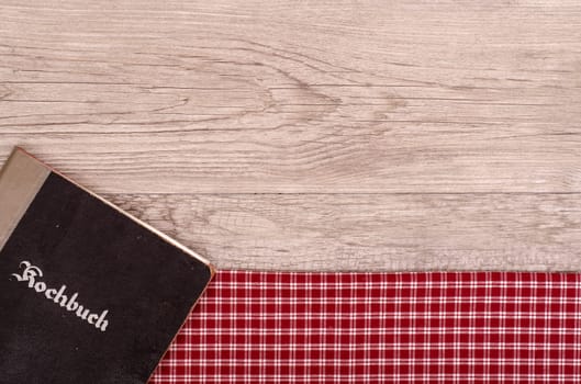 Cookbook on checkered napkin and weathered wood