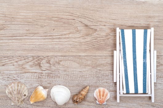 Sun lounger and various shells on weathered wood