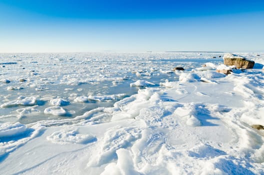 The coast of Baltic sea held down by an ice