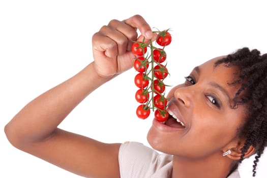 Young happy black / african american woman holding tomatoes, isolated on white background