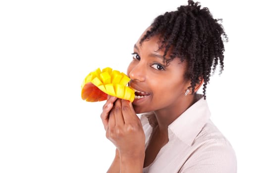 Young happy black / african american woman eating fresh mango isolated on white background