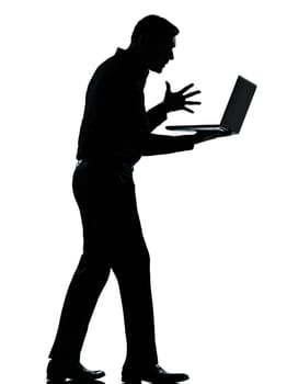 one caucasian business man computing computer laptop angry displeased silhouette standing Full length in studio isolated on white background