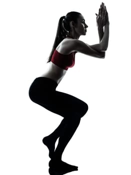 one caucasian woman exercising Garudasana eagle pose in silhouette studio isolated on white background