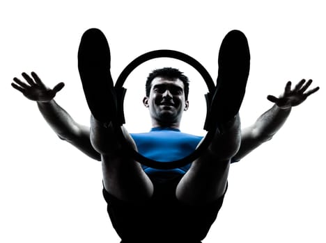 one caucasian man exercising pilates ring workout fitness in silhouette studio  isolated on white background