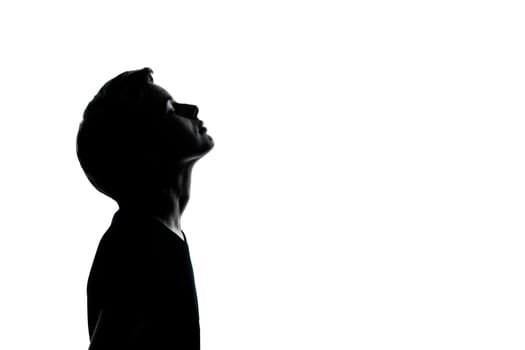 one caucasian young teenager silhouette boy or girl looking up portrait in studio cut out isolated on white background