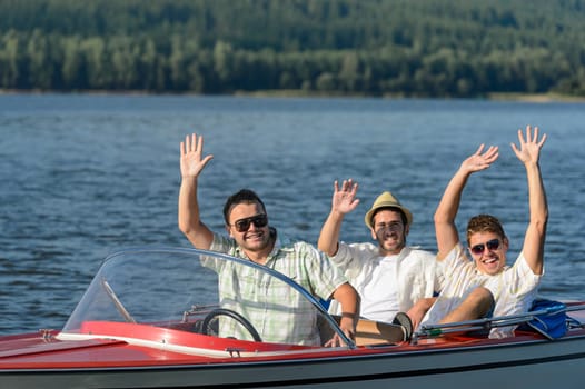 Cheerful young guys in sunglasses partying in speed boat