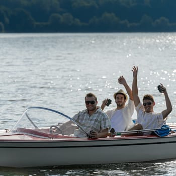 Cheerful young men party drinking beer on speed boat