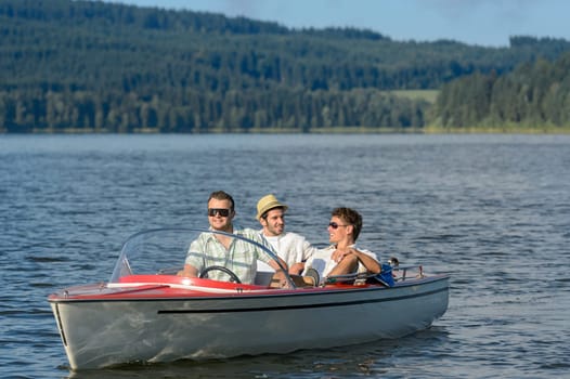 Young men sitting in motorboat in scenic landscape