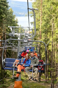 Chairlift going through forest with young people