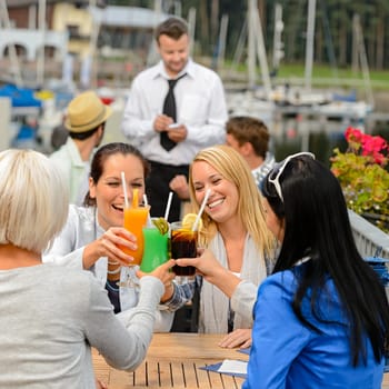 Women celebrating with cocktails at harbor restaurant