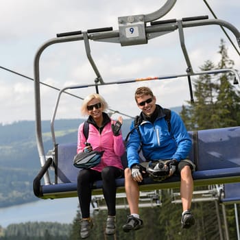 Young smiling couple sitting on chairlift