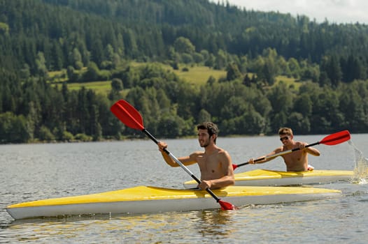 Young men kayaking summertime vacation on river paddling