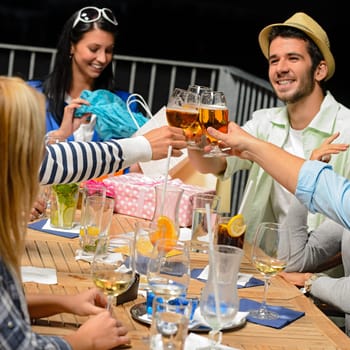Young people celebrating birthday toasting with beer outdoors