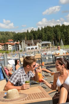 Young couple drinking cocktail at beach bar summertime