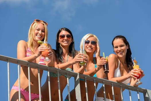 Beautiful women in bikinis and sunglasses smiling with drinks